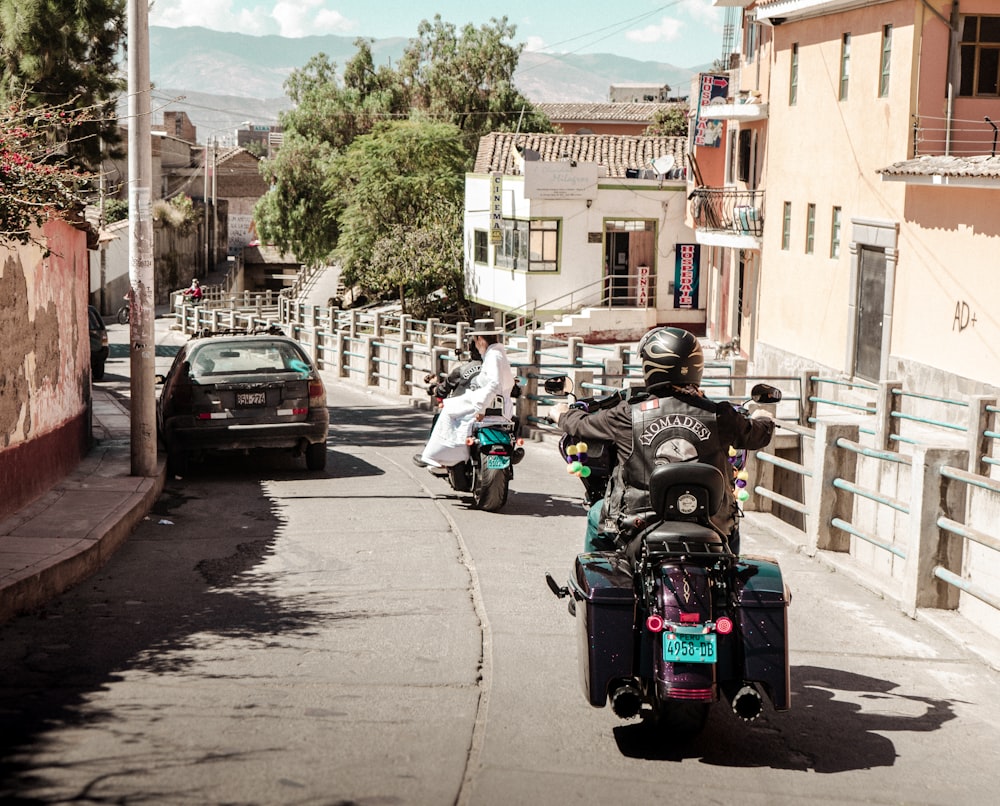 a group of people riding motorcycles down a street