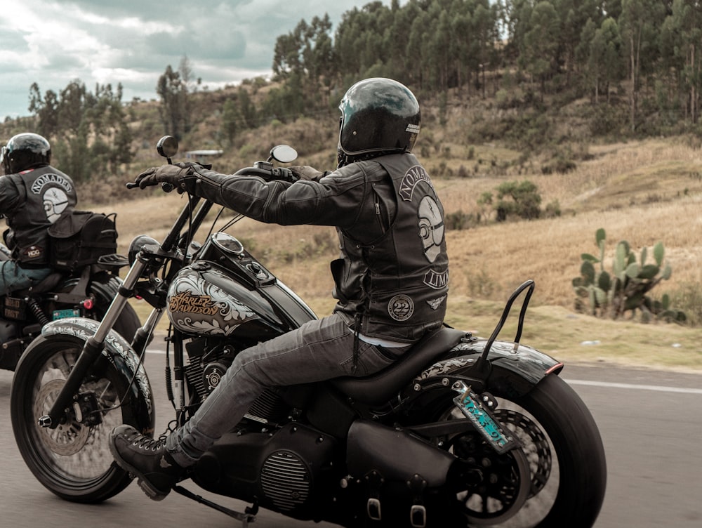 two people riding motorcycles on a road