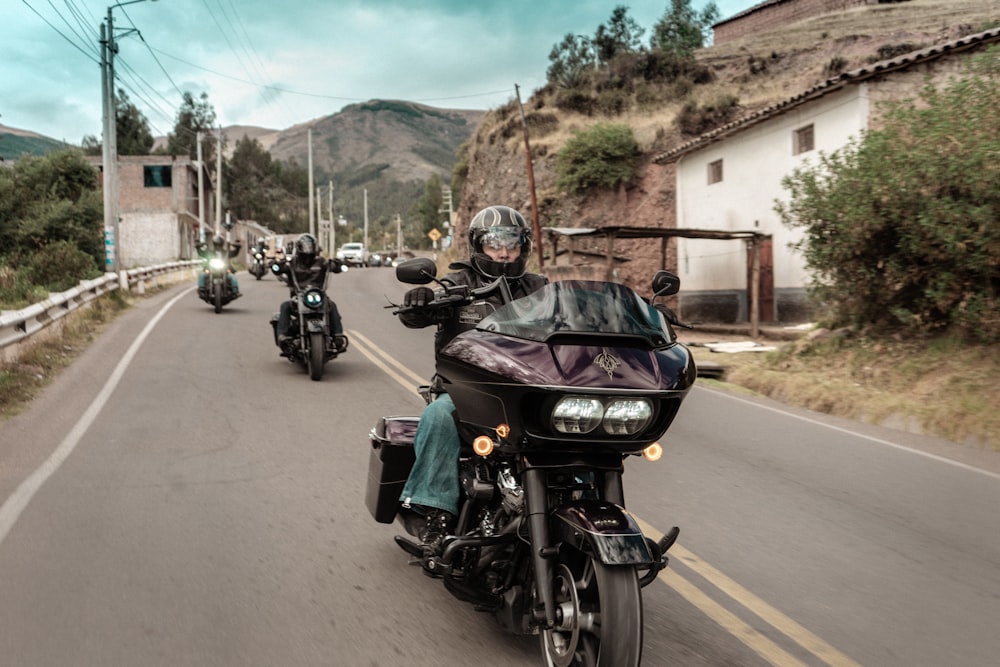 a group of people riding motorcycles down a street