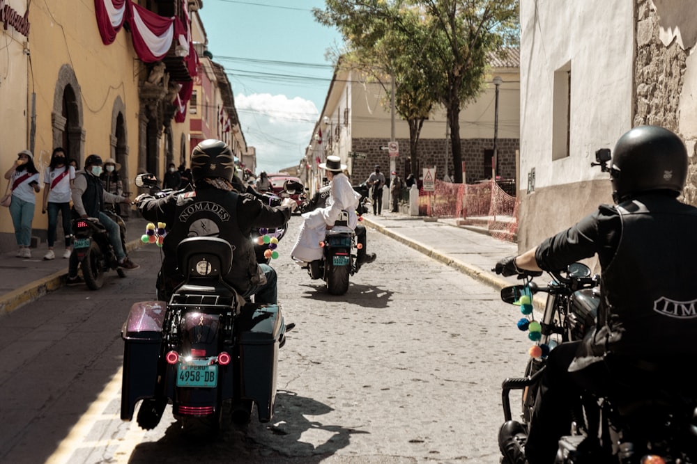 a group of people riding motorcycles down a street