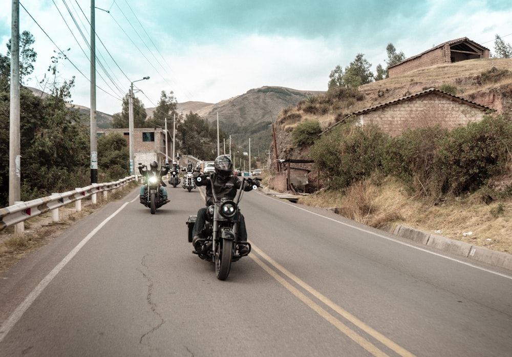 a group of motorcyclists riding down the road