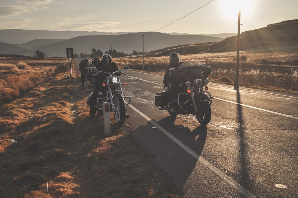 a group of people riding motorcycles down a road