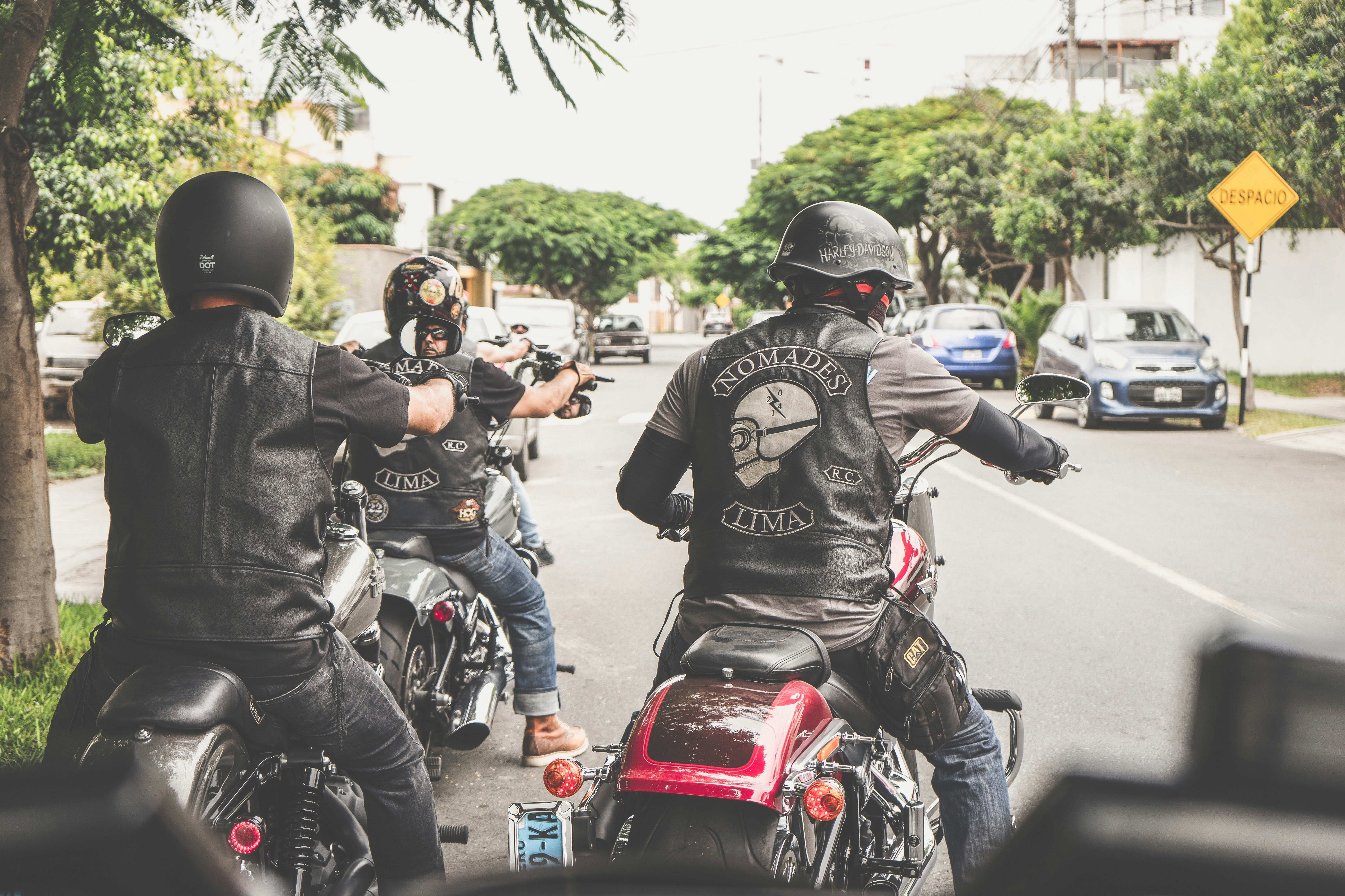 a group of men riding motorcycles down a street