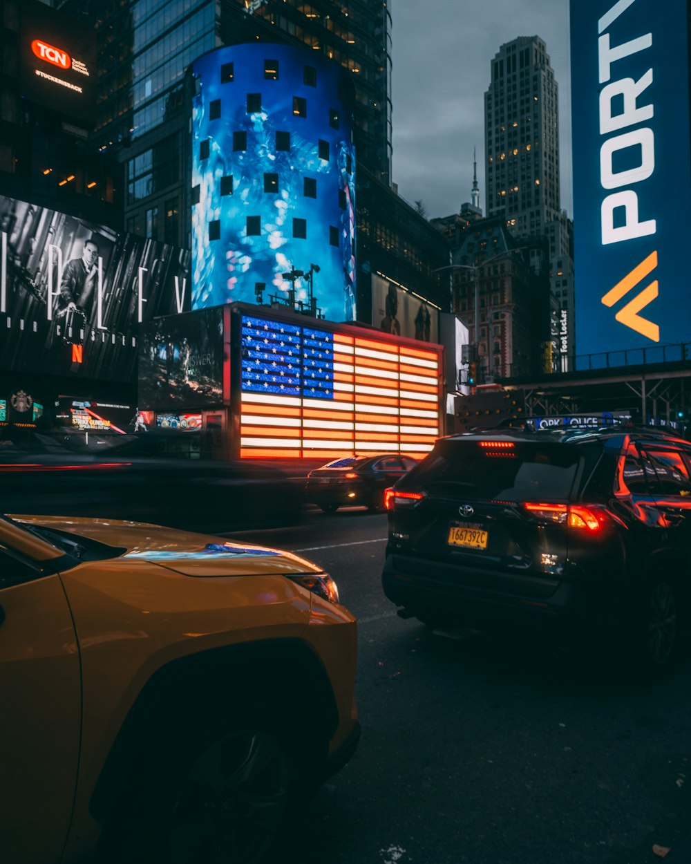 a city street filled with traffic next to tall buildings