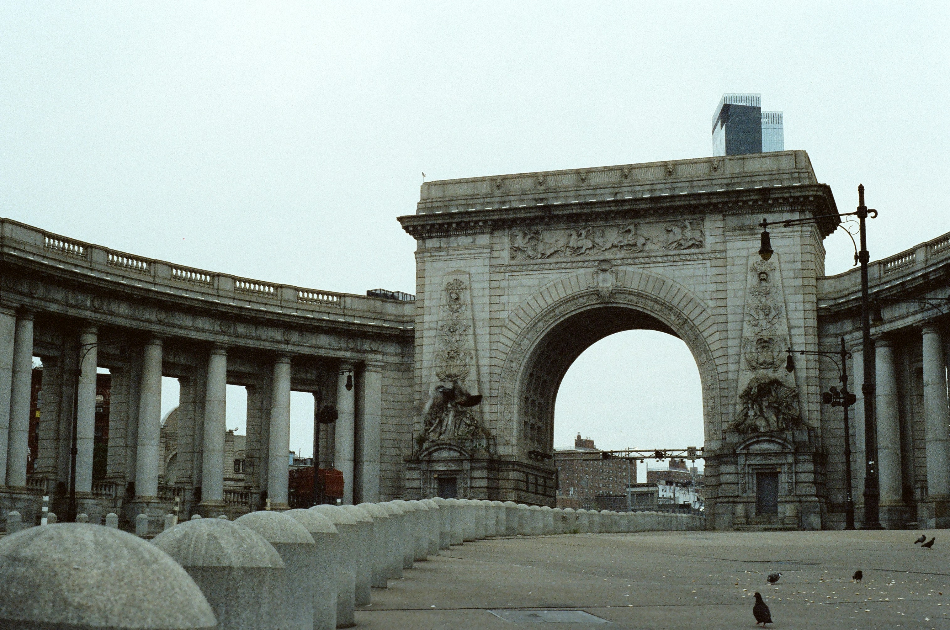 A stone arch with a clock tower in the background