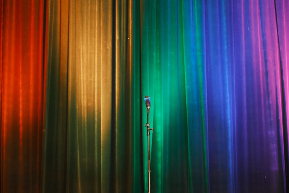 a microphone in front of a rainbow colored curtain