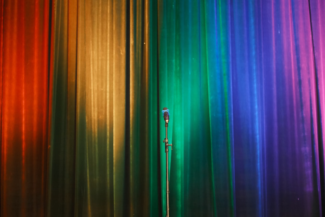 a microphone in front of a rainbow colored curtain,