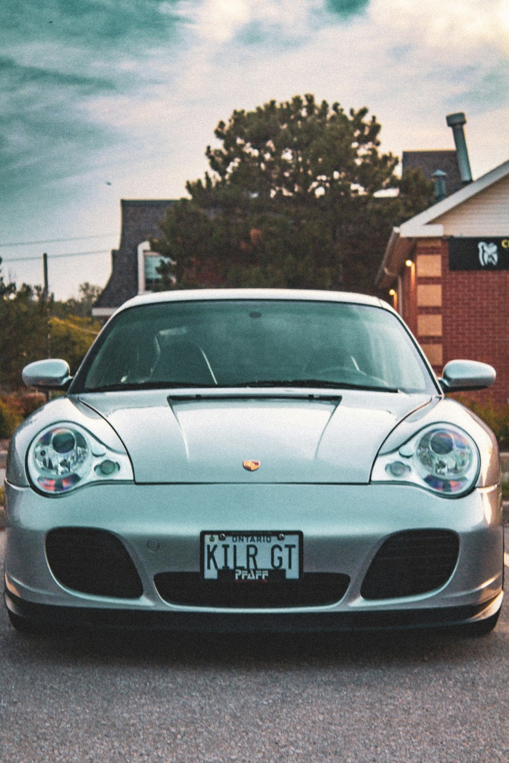 a silver sports car parked in front of a house