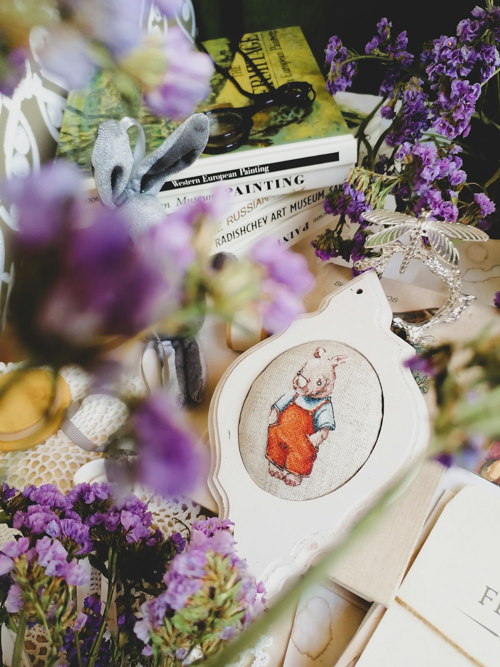 a table topped with purple flowers and books