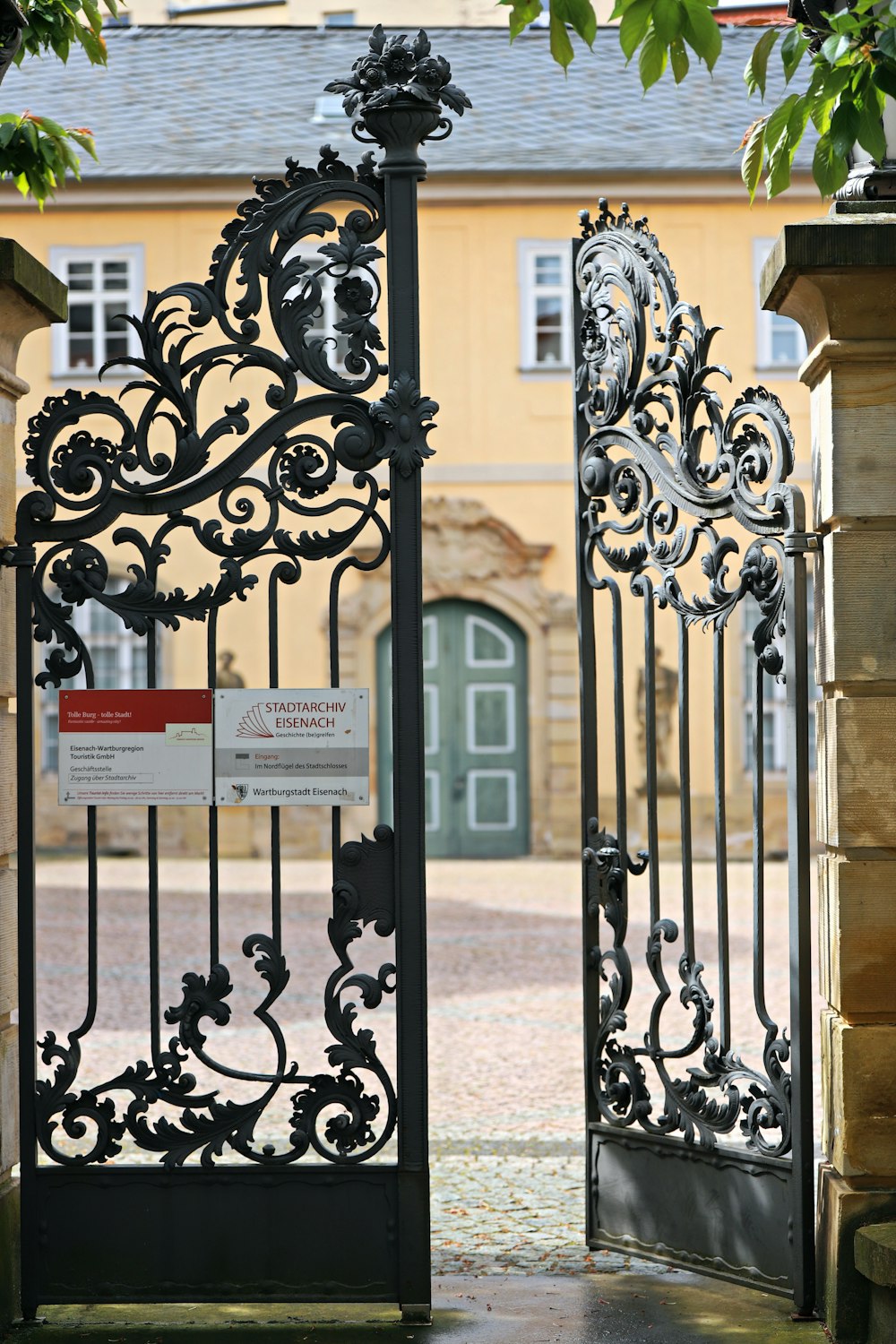 an iron gate with a sign on it in front of a building