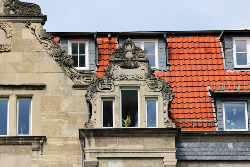 a building with a red tiled roof and windows