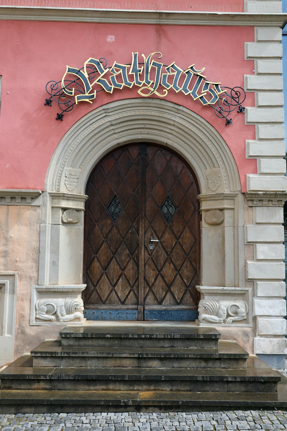 a building with a large wooden door and a sign above it