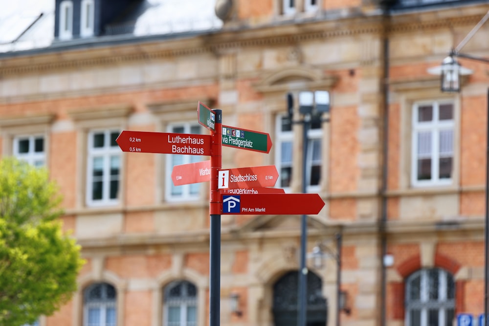 a red street sign sitting in front of a tall building