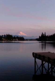 a dock on a lake with a mountain in the background