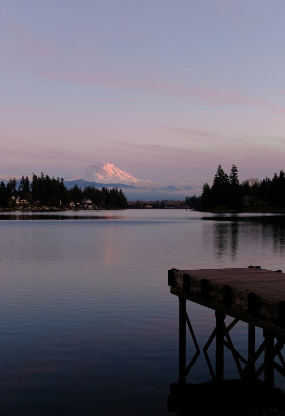 a dock on a lake with a mountain in the background