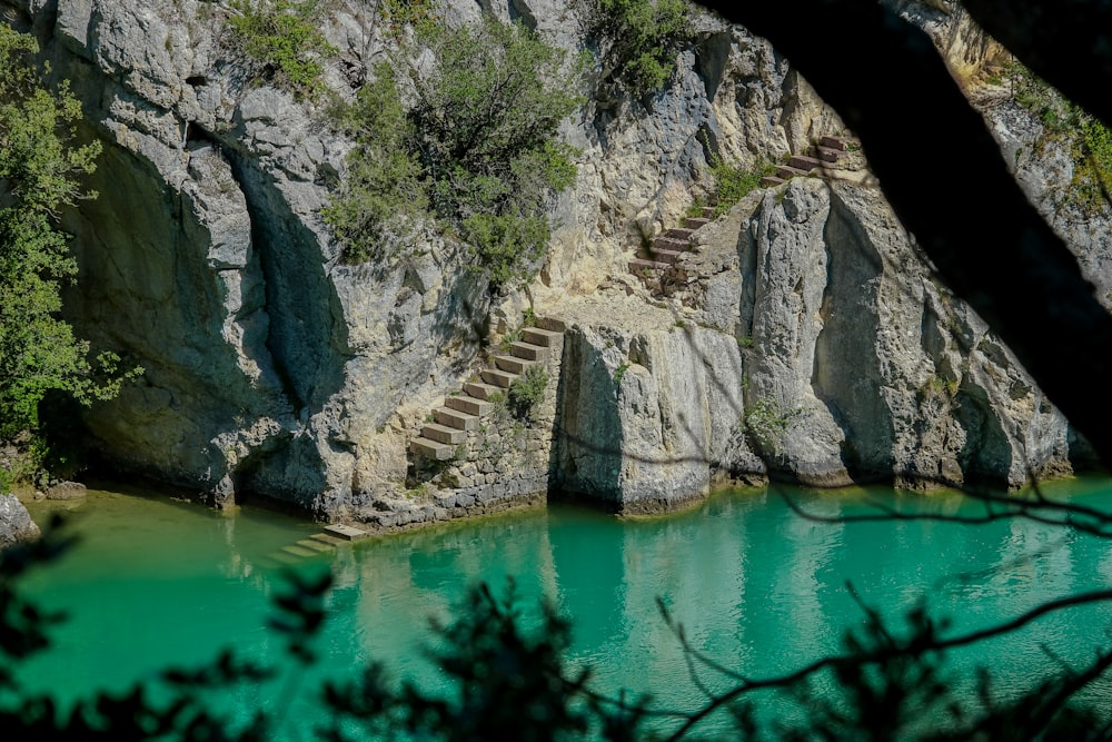 a body of water surrounded by a rocky cliff