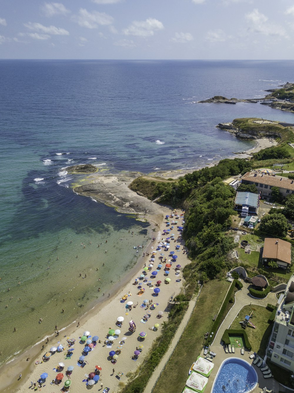 an aerial view of a beach with umbrellas