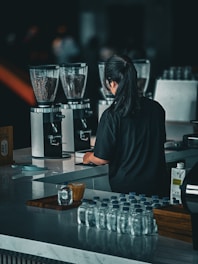 a woman standing at a bar preparing drinks