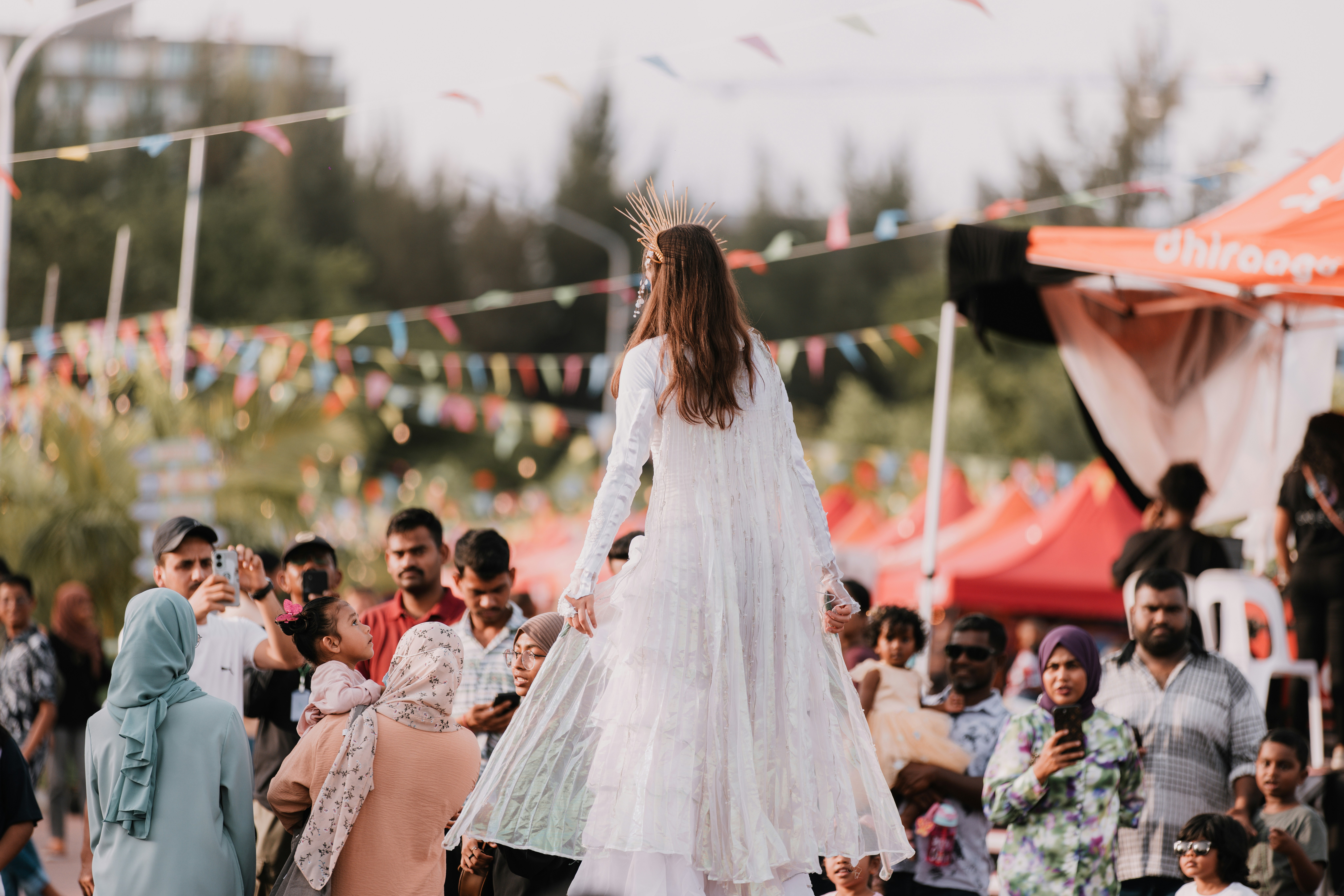 a woman in a white dress walking on a runway