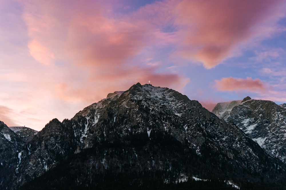 a view of a mountain with a pink sky in the background