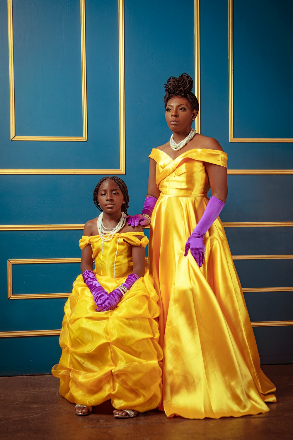 a woman and a child dressed in yellow dresses