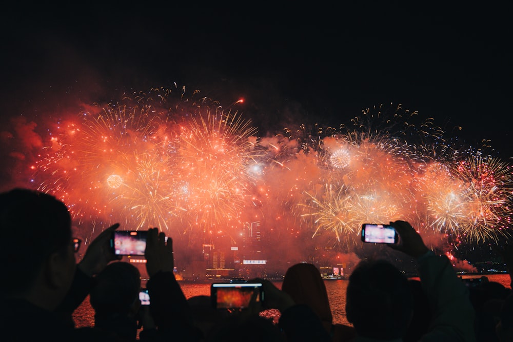 a group of people taking pictures of fireworks