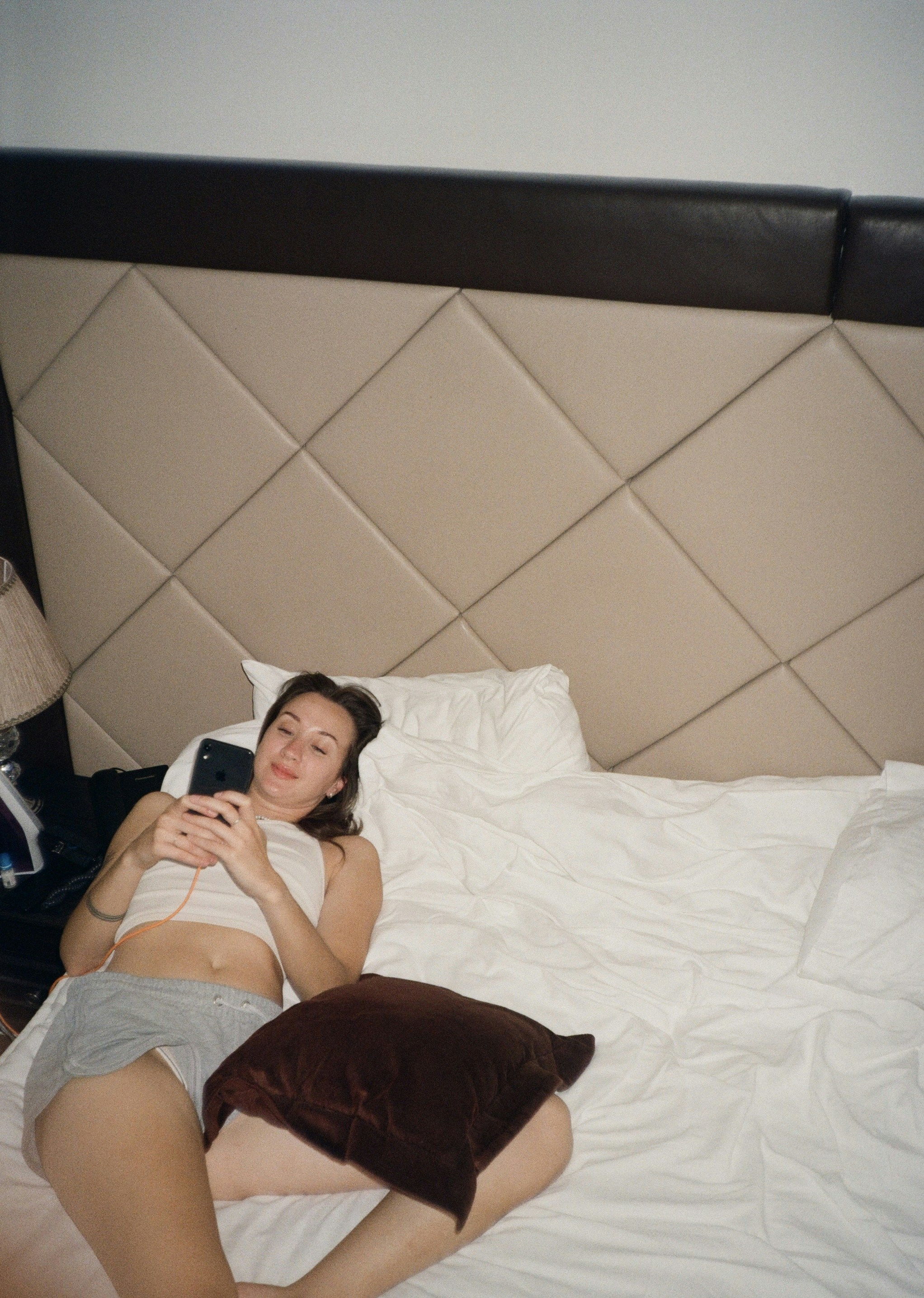 a woman laying in bed with a cell phone