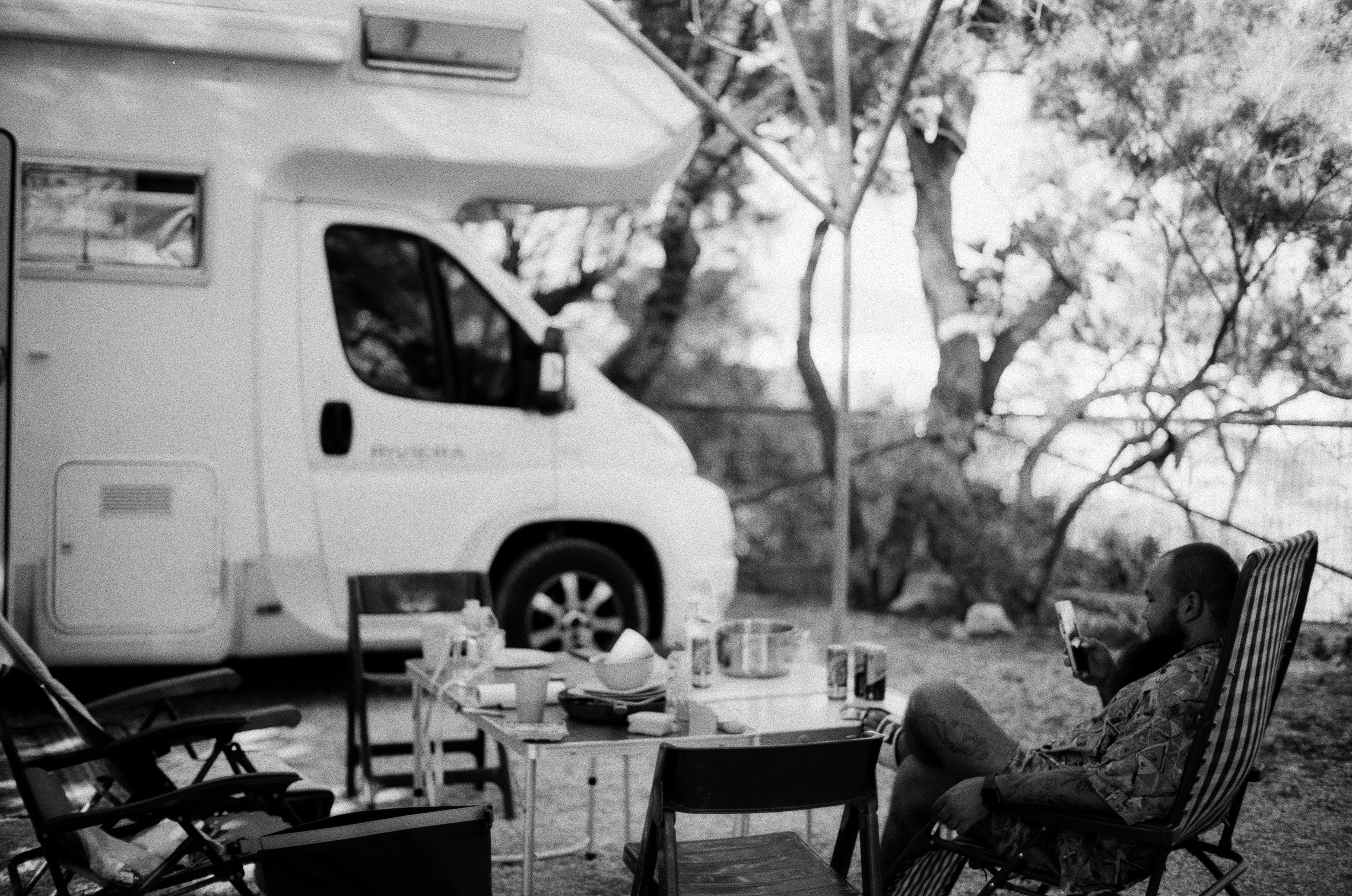 a man sitting in a chair in front of a camper