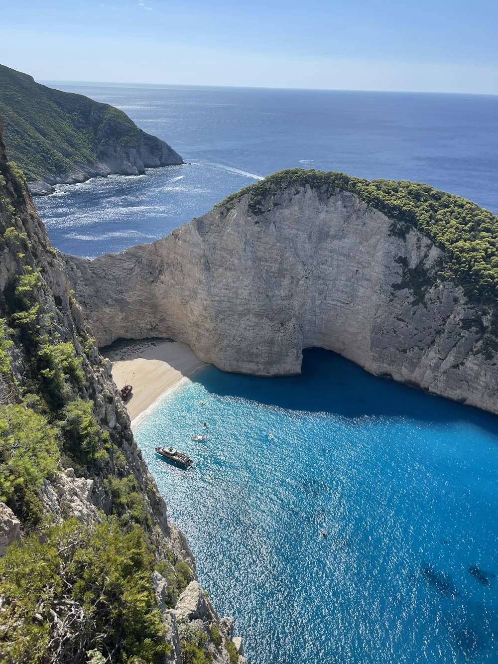 an aerial view of a beach with a boat in the water