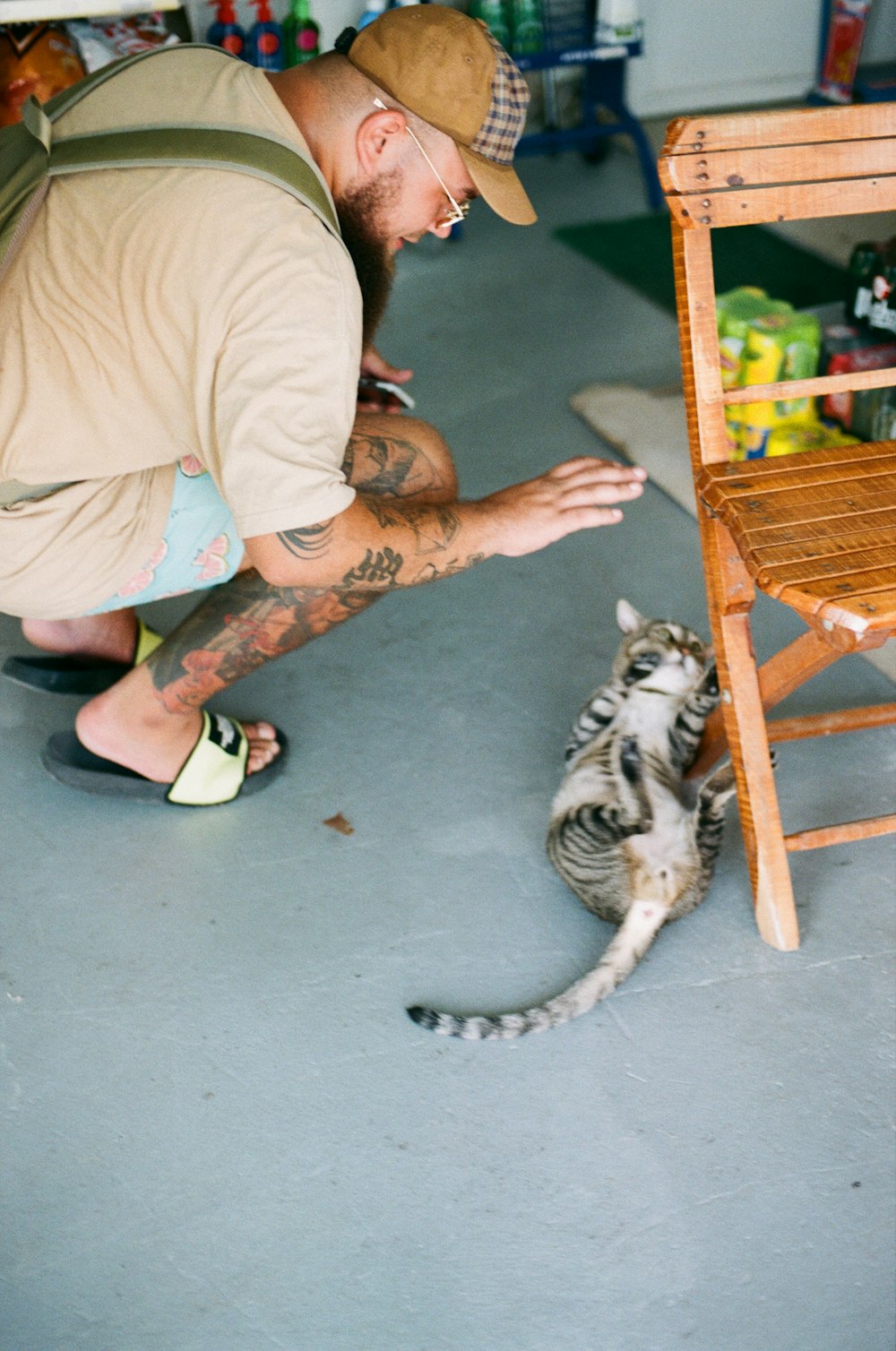 a man petting a cat on the floor