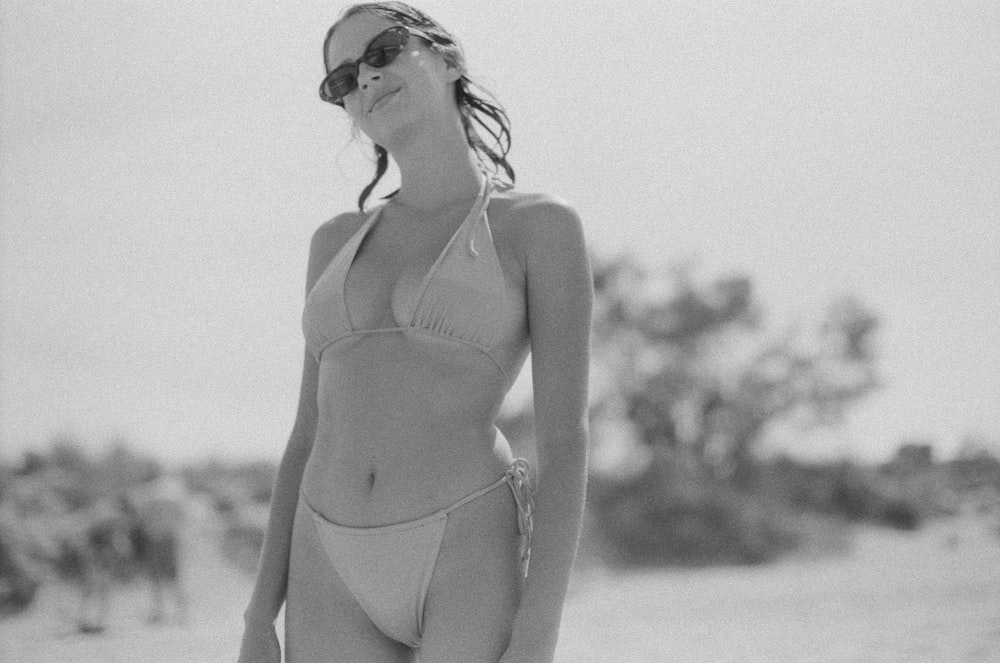 una donna in bikini in piedi sulla spiaggia
