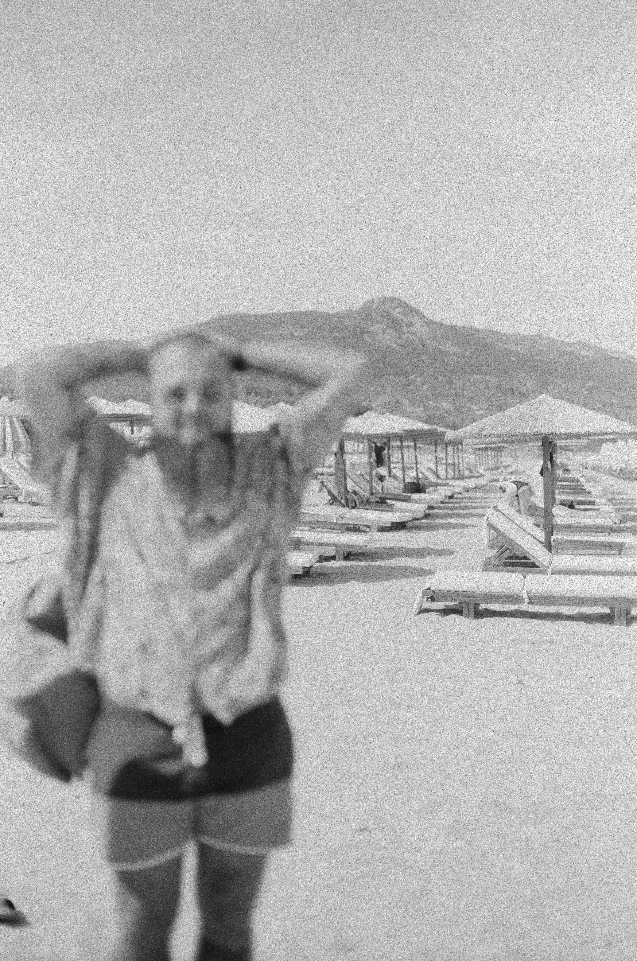 a woman standing on top of a sandy beach
