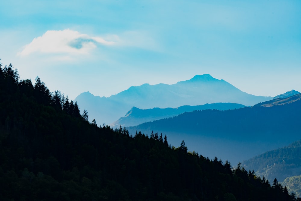 a view of a mountain range with trees and mountains in the background