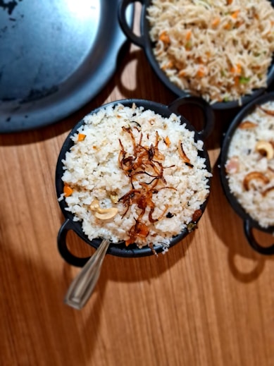 a wooden table topped with bowls of food
