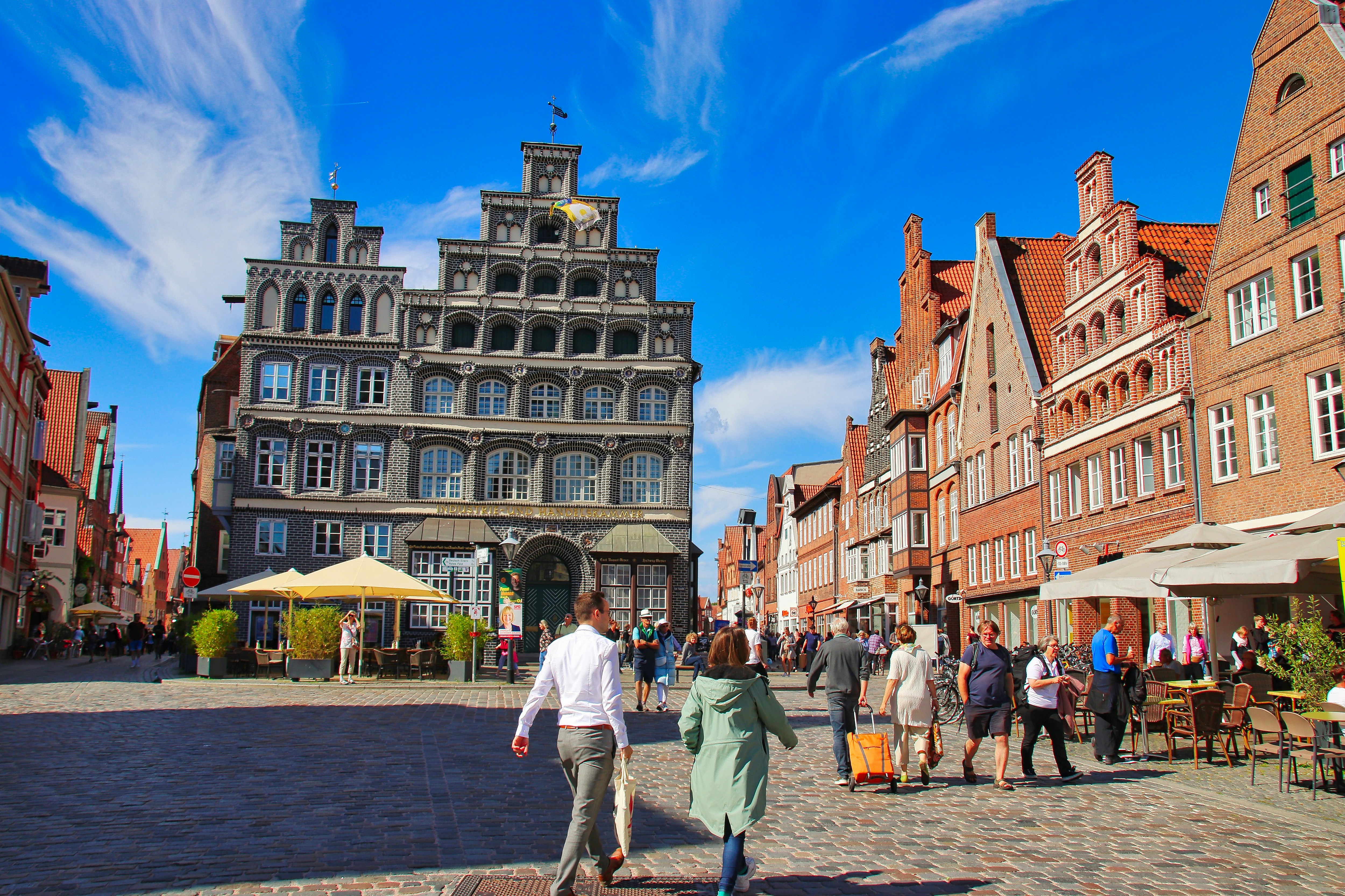 a group of people walking down a cobblestone street