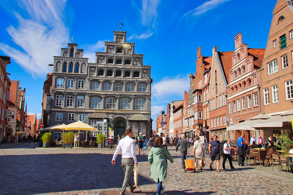 a group of people walking down a cobblestone street