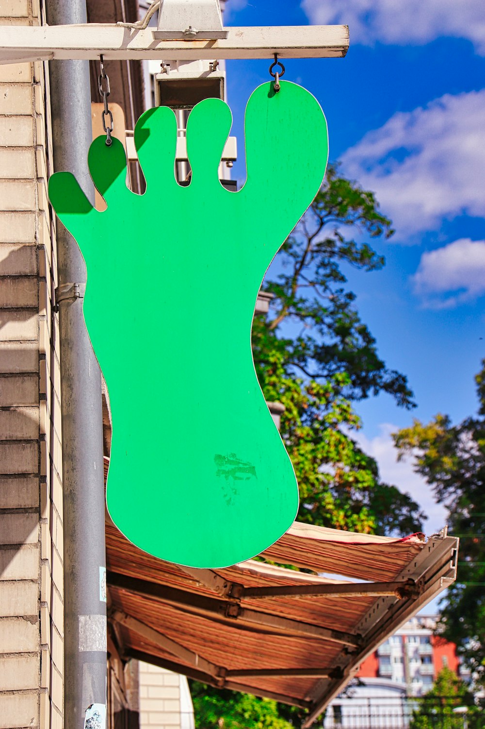 a green sign hanging from the side of a building