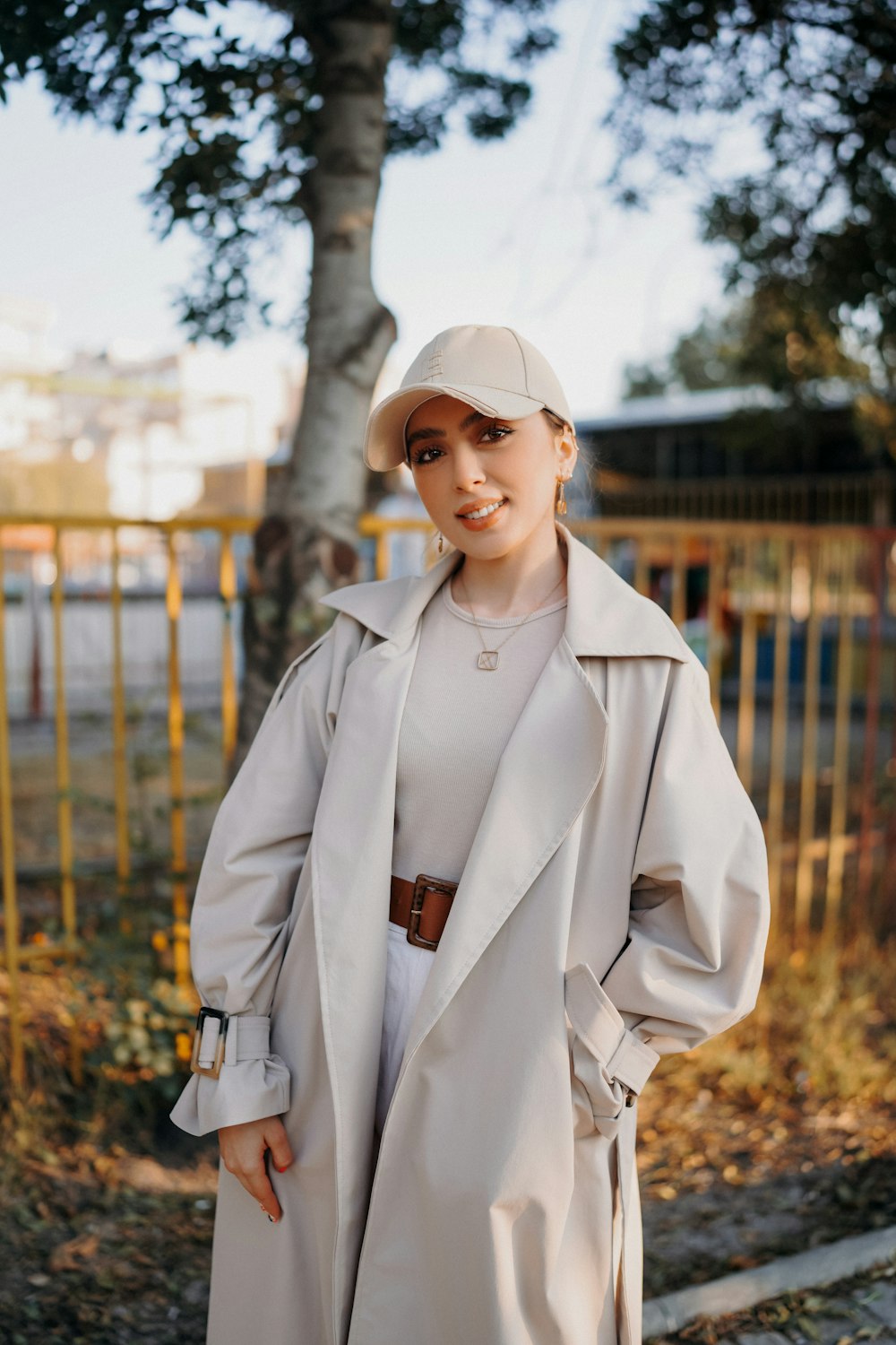 a woman wearing a white hat and trench coat