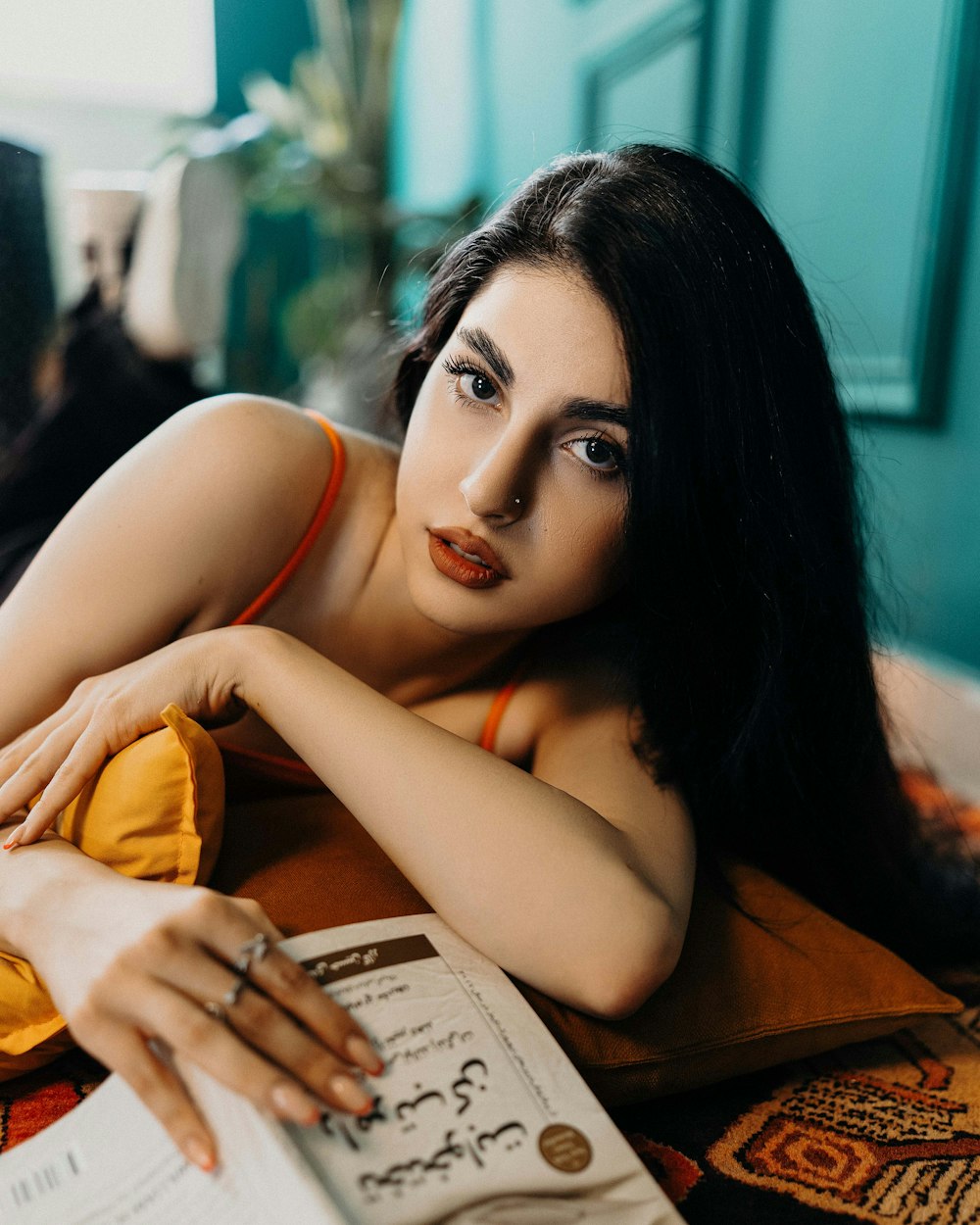 a woman laying on top of a bed next to a book