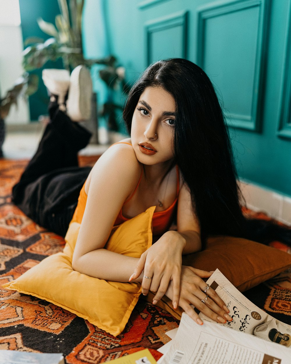 a woman laying on a bed with a magazine