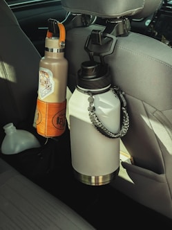 a car seat with a water bottle and a cell phone in it