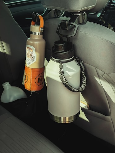 a car seat with a water bottle and a cell phone in it