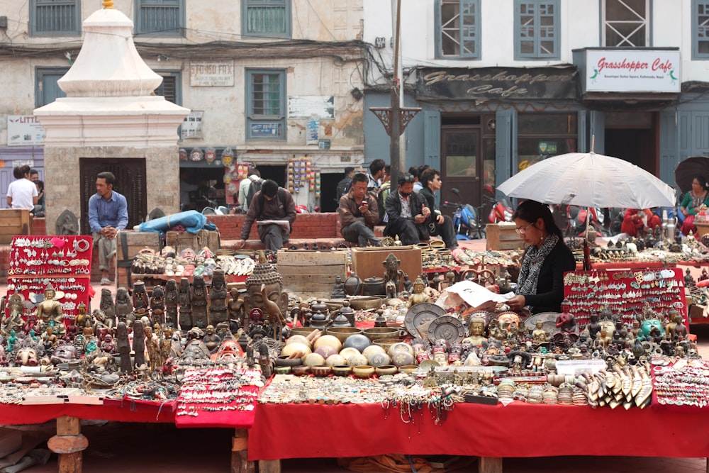 a woman with an umbrella standing in front of a market