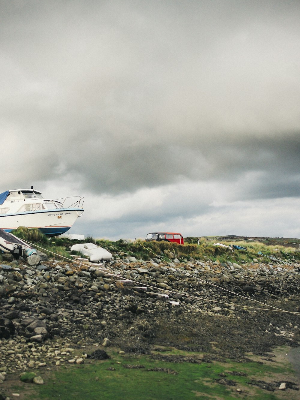 a boat sitting on top of a rocky beach