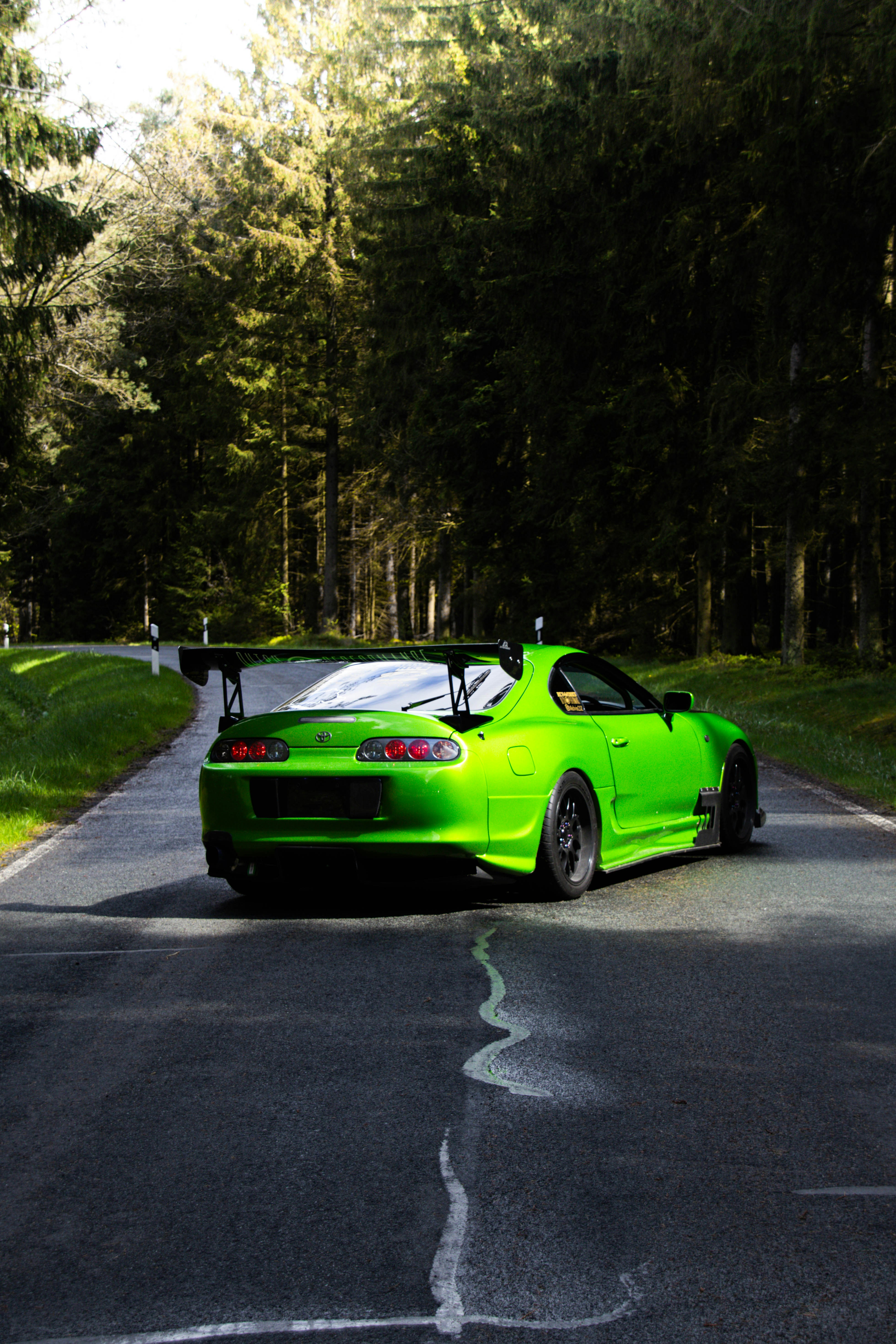 A bright green sports car driving down a road
