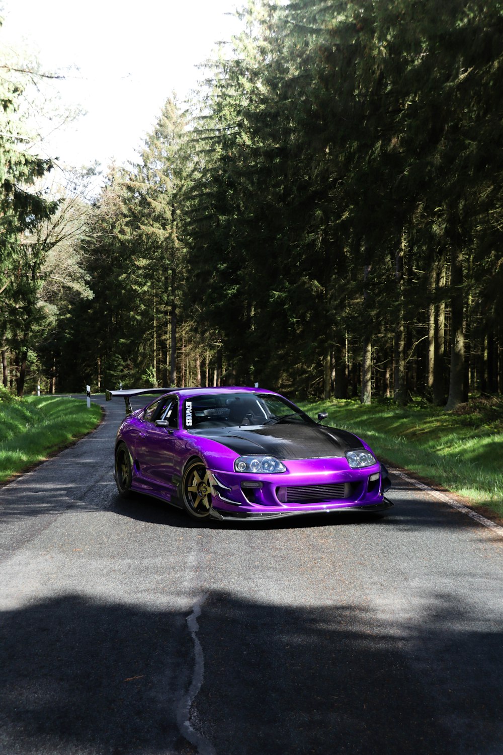 a purple car parked on the side of a road