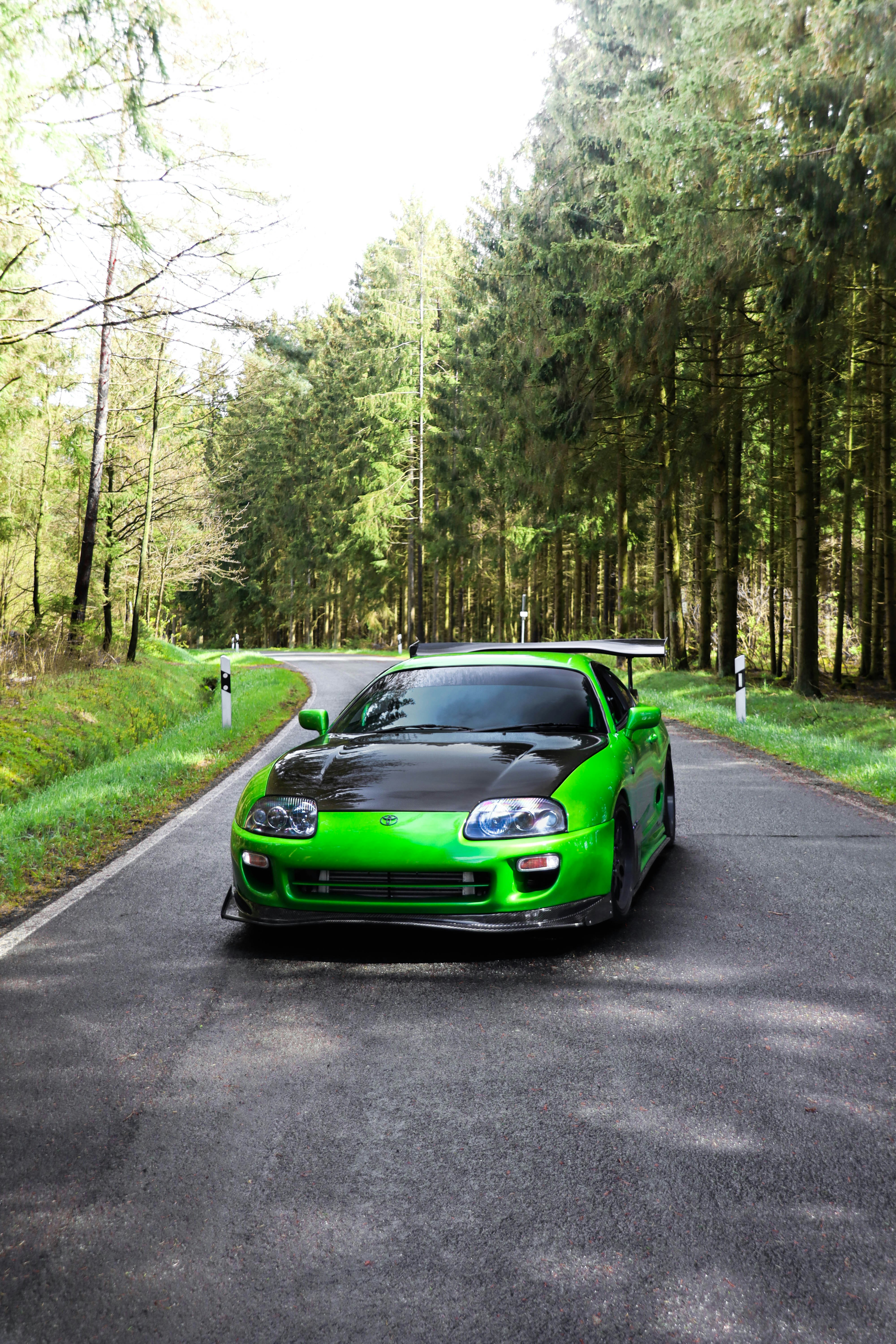 A green sports car parked on the side of a road