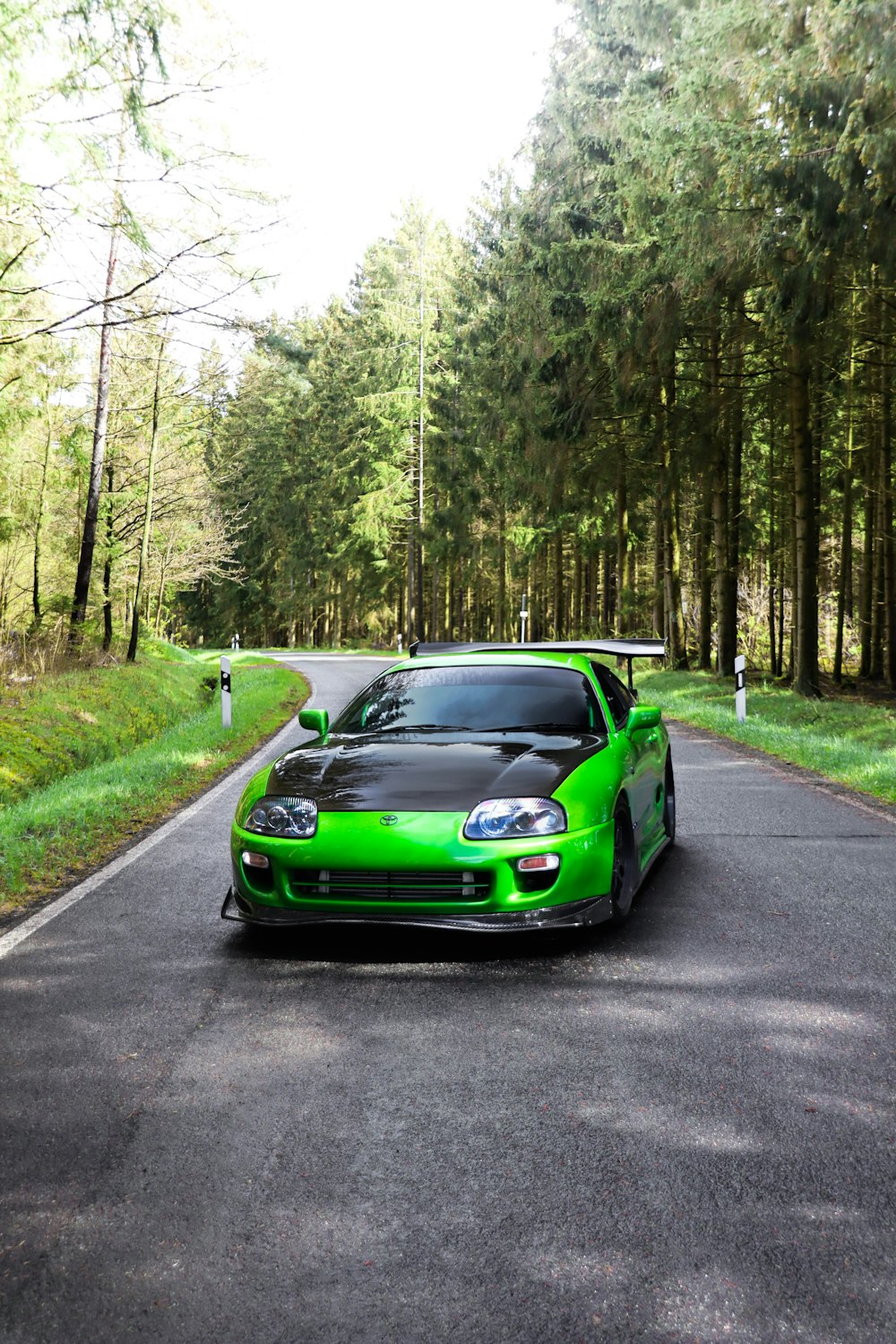 a green sports car parked on the side of a road