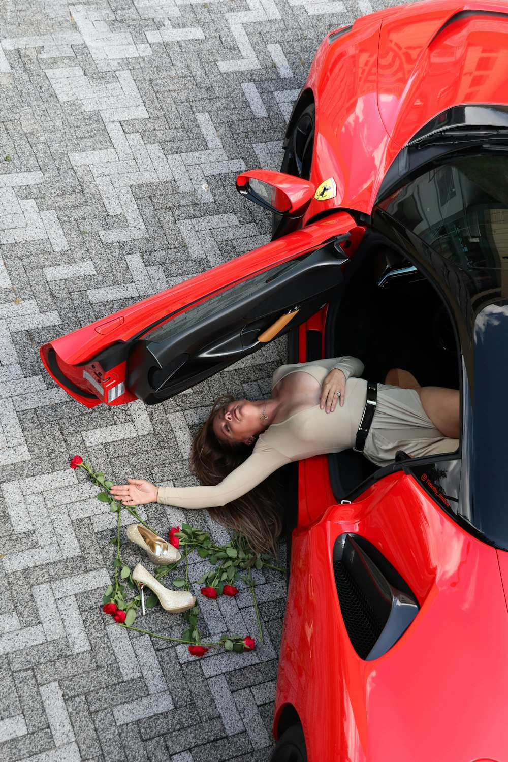 a woman leaning out of a red sports car