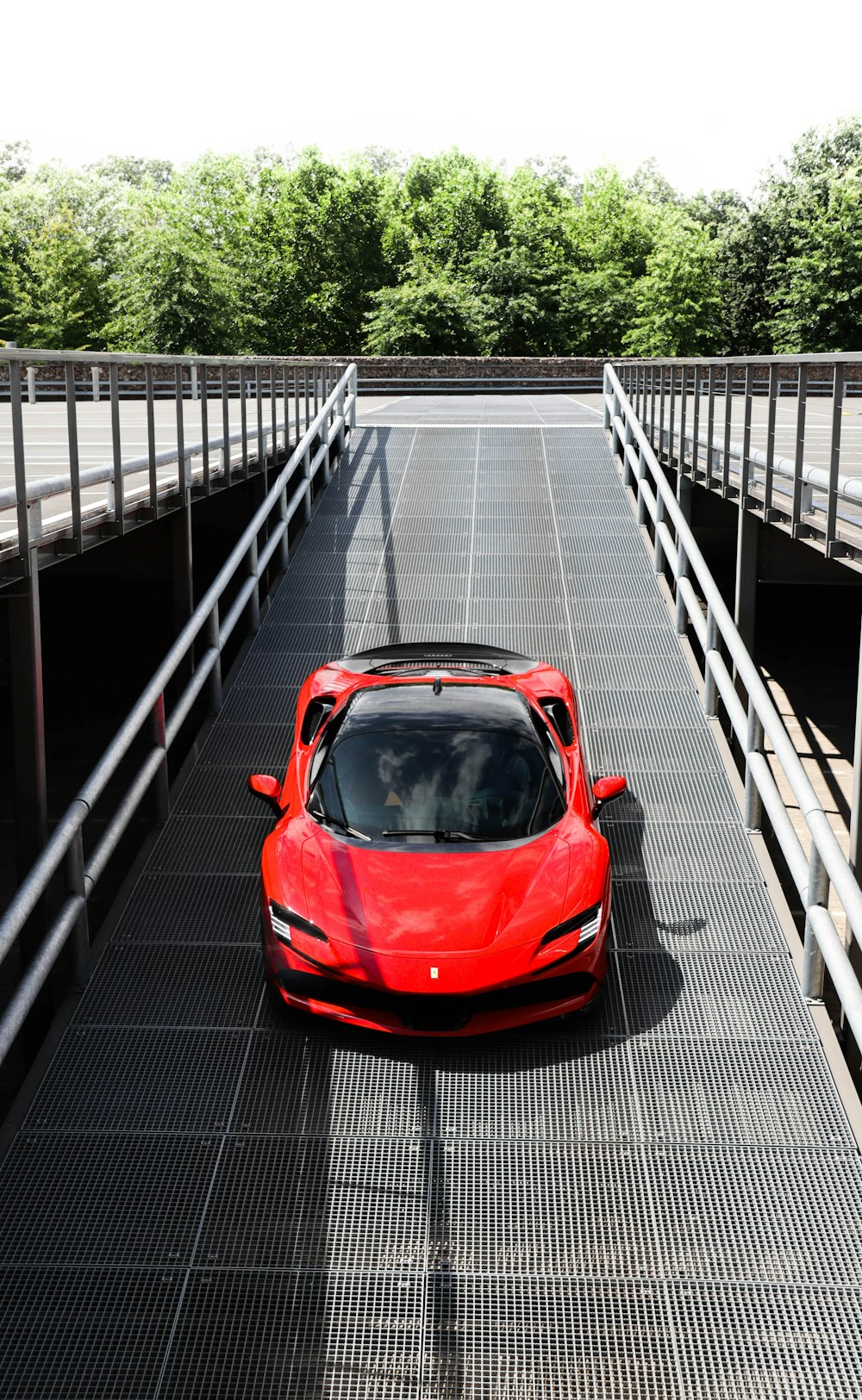 a red sports car is parked on a bridge